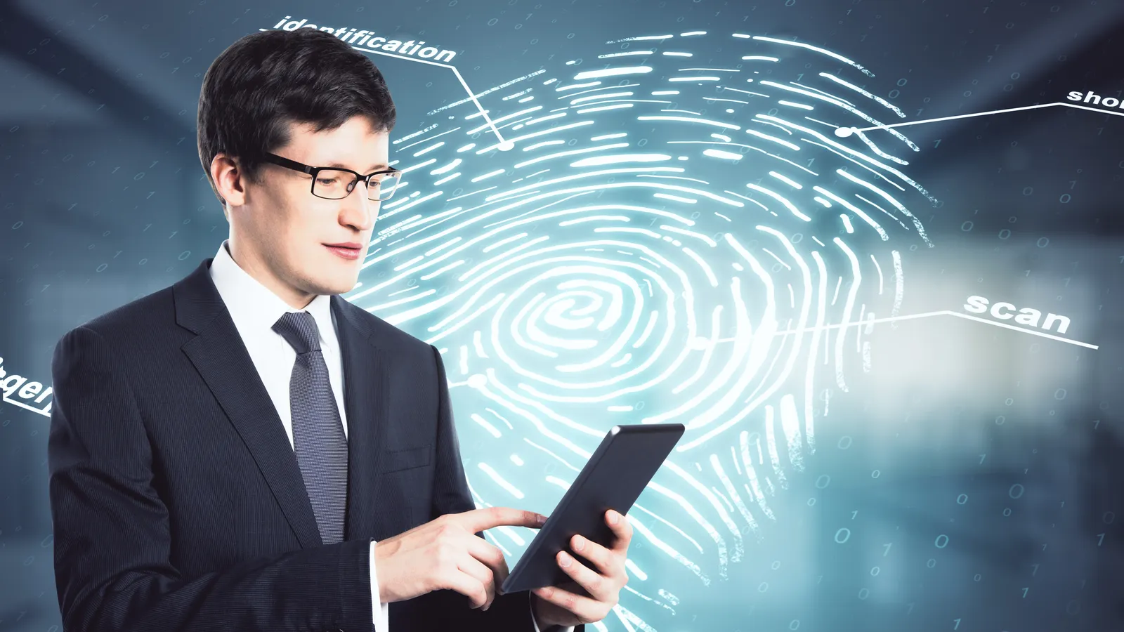 A man in a suit using a tablet in front of a large glowing fingerprint labelled identification, scan and security.